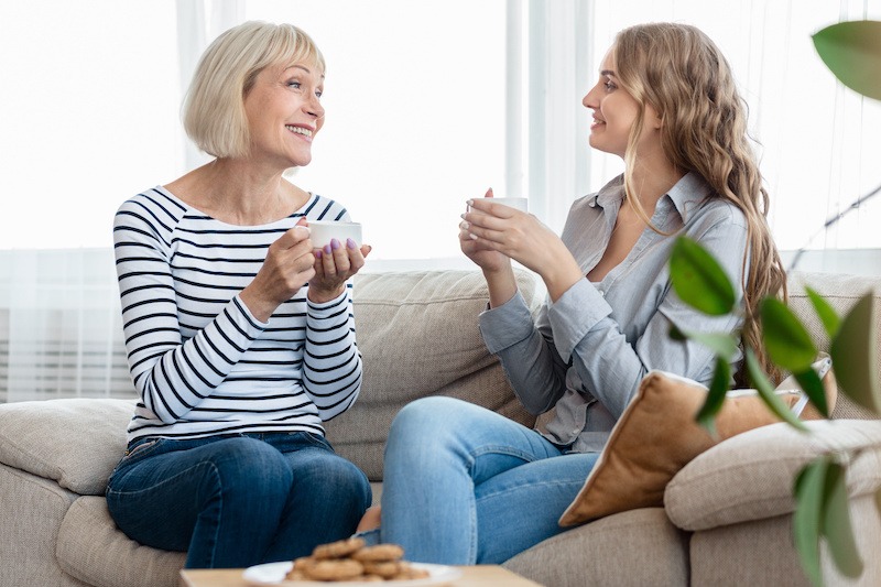 Two women talking on couch over coffee